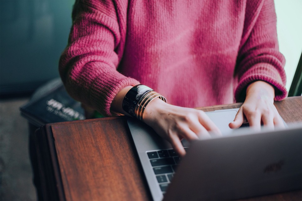 Frau mit handgelenk Schmuck an einem Laptop